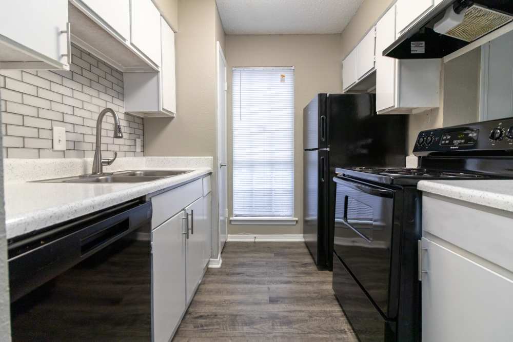 Kitchen with black appliances at Oak Ridge Apartments in San Antonio, Texas