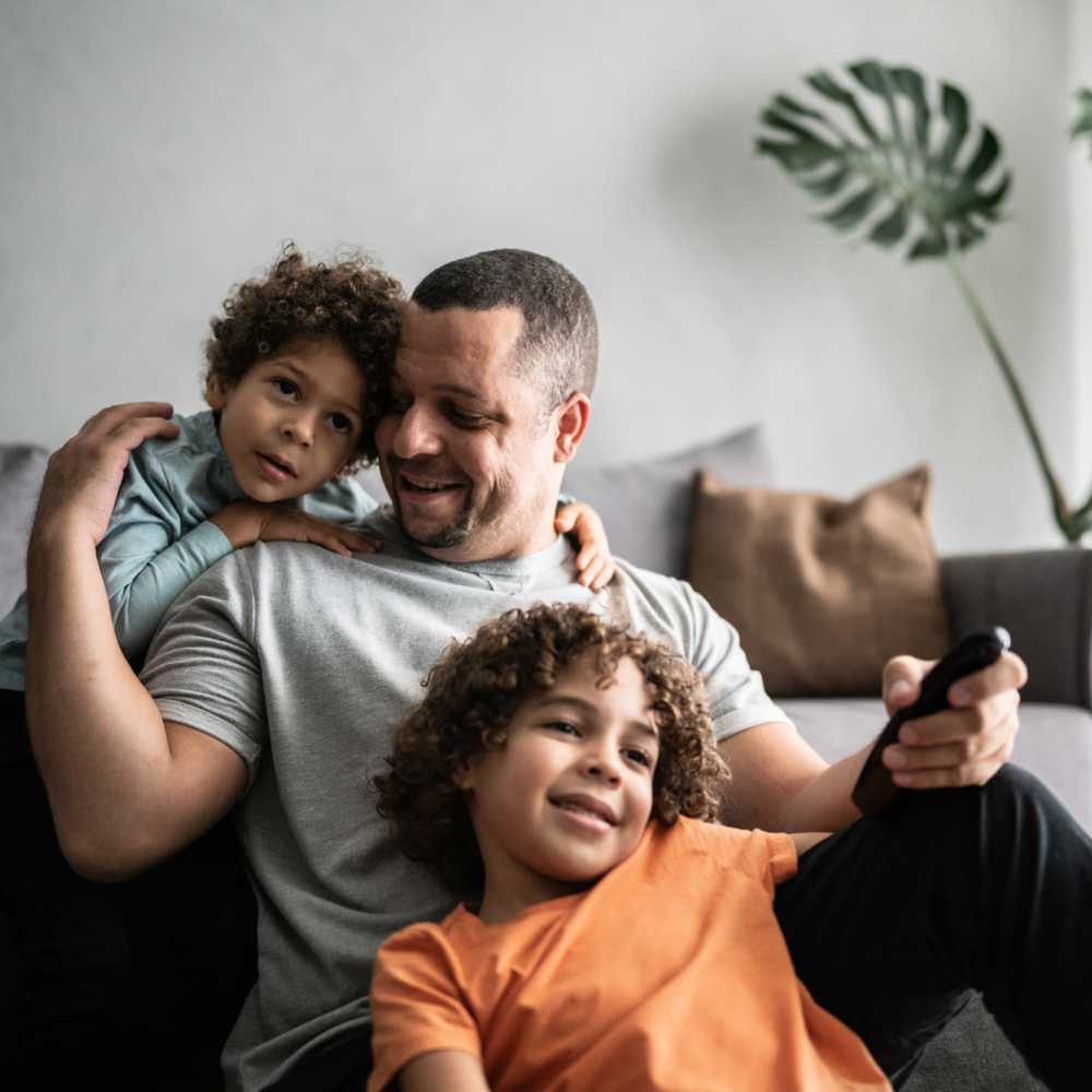 Resident with his kids in the living area of an apartment at Ridge Commons in Lafayette, Louisiana