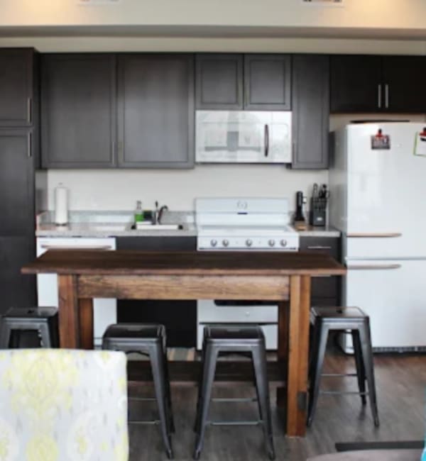 Kitchen with modern appliances and breakfast bar at 440 on Third Apartments in Baton Rouge, Louisiana