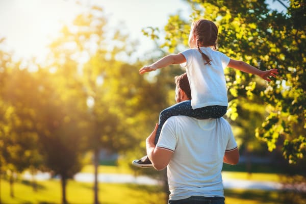 Dad with his daughter on his shoulders in a park near Aviara at Mountain House in Mountain House, California