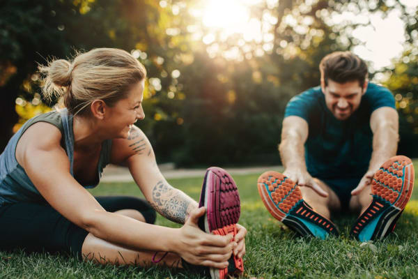 Two people stretching at a park near The Sage Collection in Everett, Washington