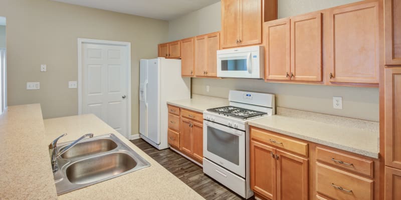 A kitchen with appliances in a home at The Village at Whitehurst Farm in Norfolk, Virginia