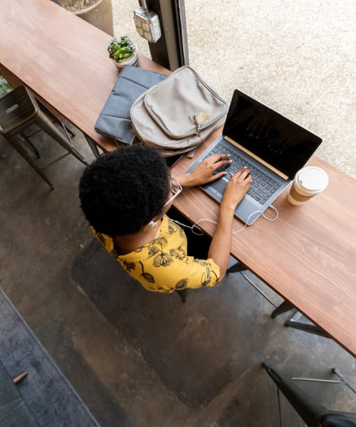 A resident using her laptop in the clubhouse at The Avenue at South Orange Apartments in South Orange, New Jersey