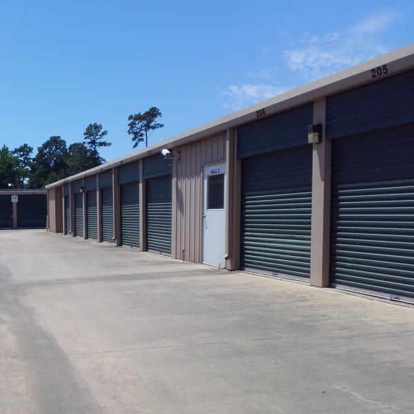 Outdoor storage units with green doors at StorQuest Self Storage in Spring, Texas