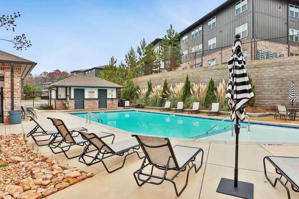 A beautiful swimming pool with lounge seating  at Flats at Mount Zion in Stockbridge, Georgia