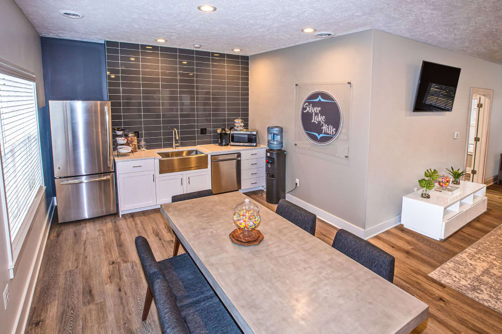 A clubhouse with a community kitchen and a large table for entertaining guests at Silver Lake Hills in Fenton, Michigan