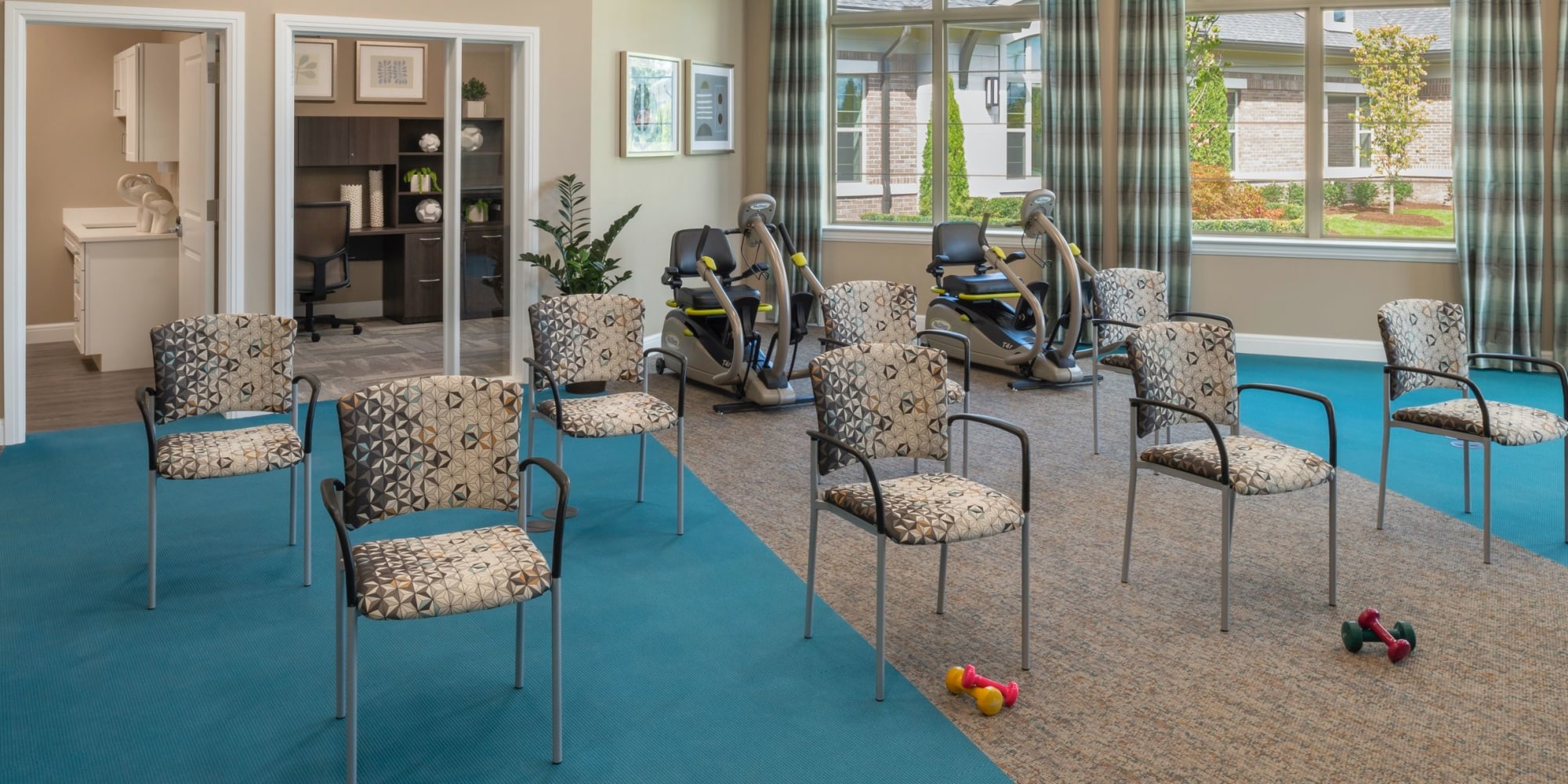 Fitness area with chairs and weights at Blossom Springs in Oakland Twp, Michigan