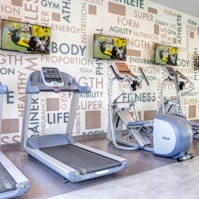 Cardio machines with individual flatscreen TVs in the onsite fitness center at Sofi Berryessa in San Jose, California