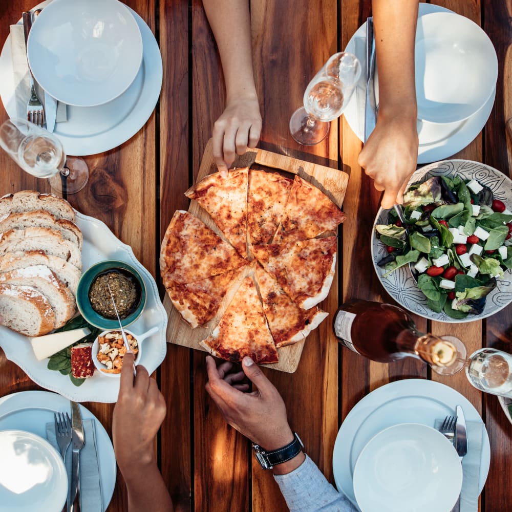 Residents sharing pizza and salad near Crystal Springs in Fort Worth, Texas