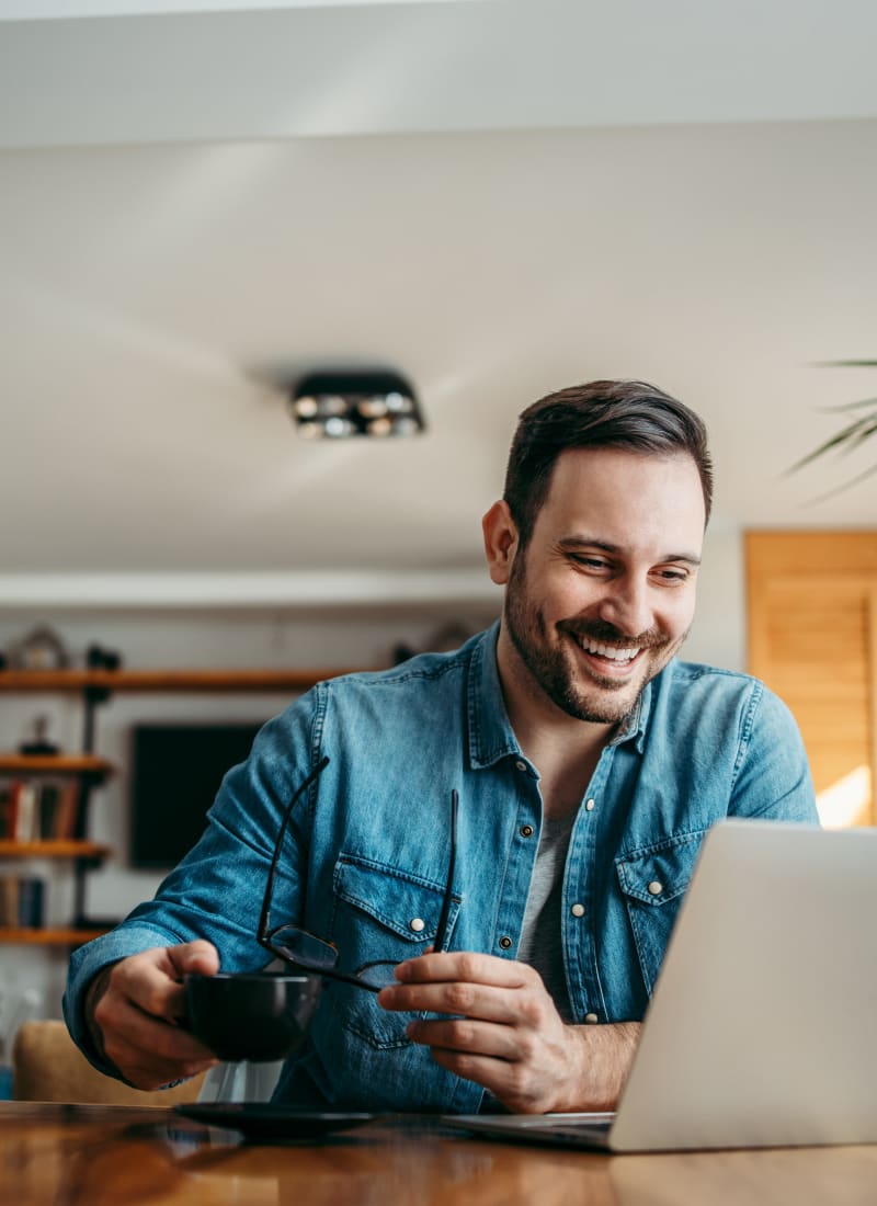 Resident working on his computer while enjoying coffee at Marquis at Bellaire Ranch in Fort Worth, Texas