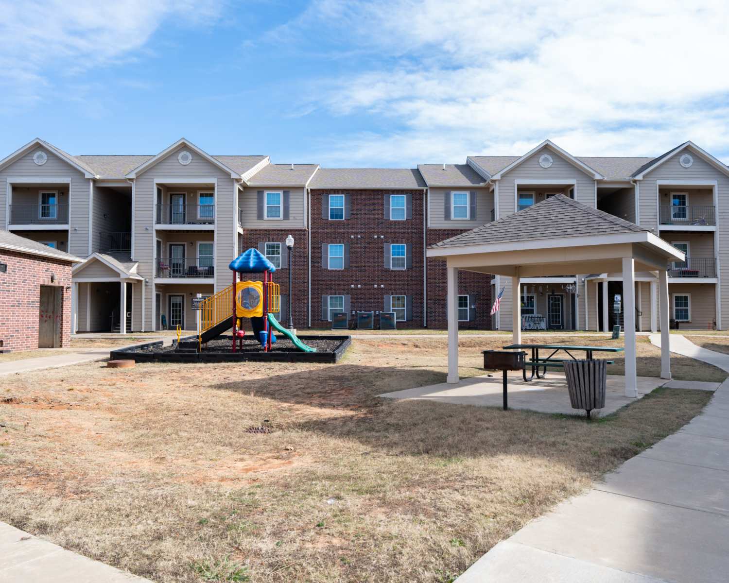Playground with picnic area beside modern apartment complex at Shawnee Park in Shawnee, Oklahoma 