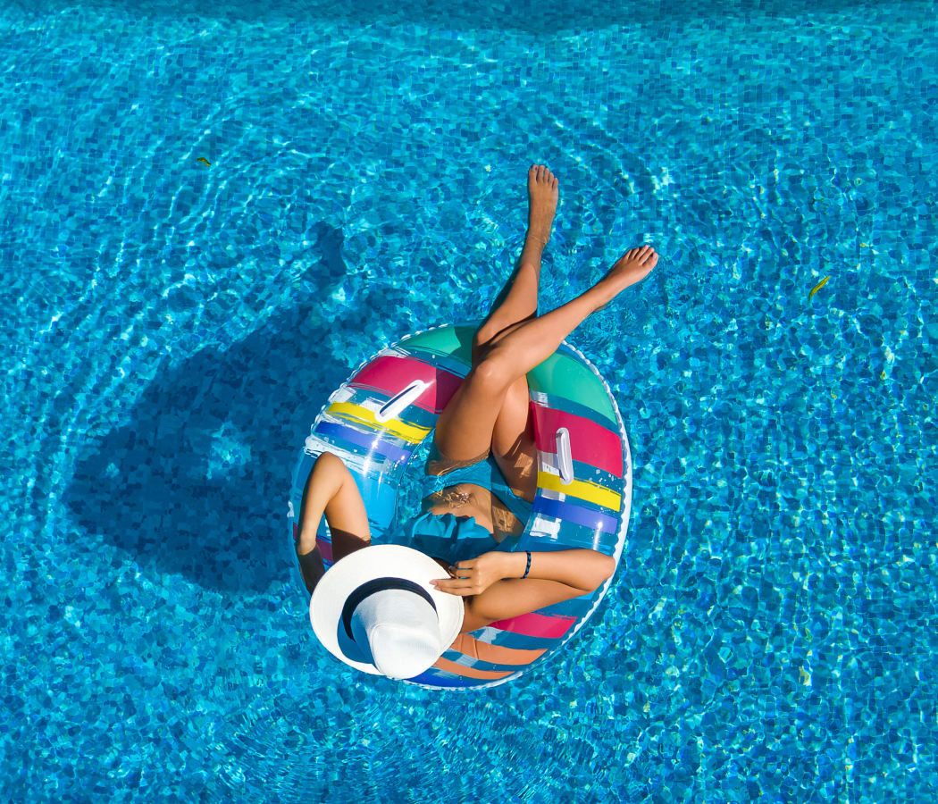 Resident relaxing in the swimming pool at IMT Beverly Arnaz in Los Angeles, California