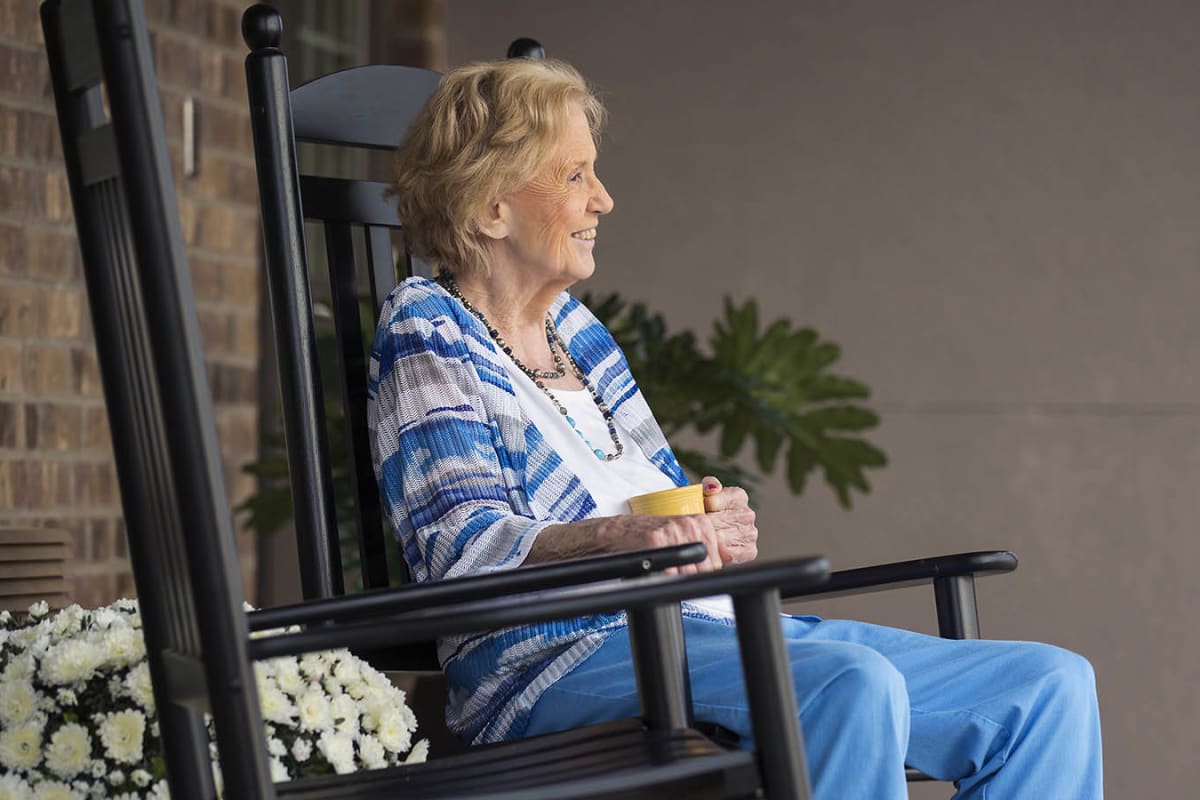 A resident enjoying her coffee outside at The Oxford Grand Assisted Living & Memory Care in Kansas City, Missouri