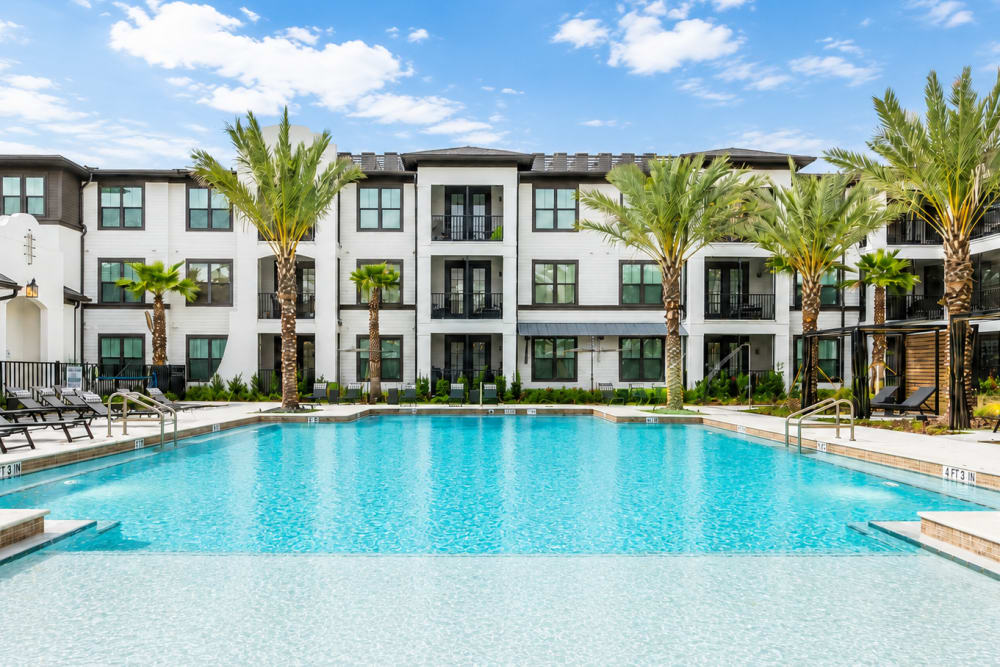Swimming pool with lounge chairs and apartment buildings at Brisa at St. Augustine in St. Augustine, Florida