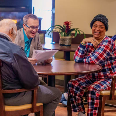 Group around a table smiling at Cascade Senior Living Services