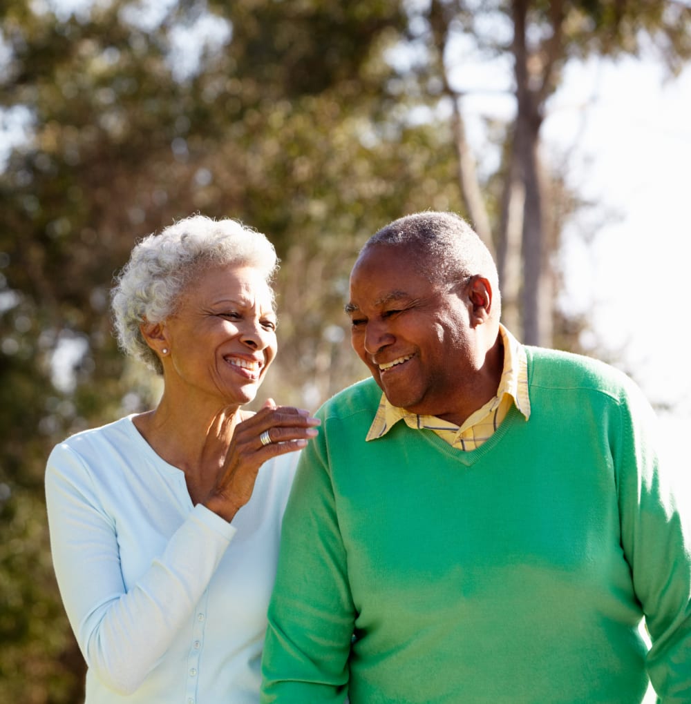 Senior living couple enjoying a sunny day and laughing at Blossom Collection in Rochester, Michigan