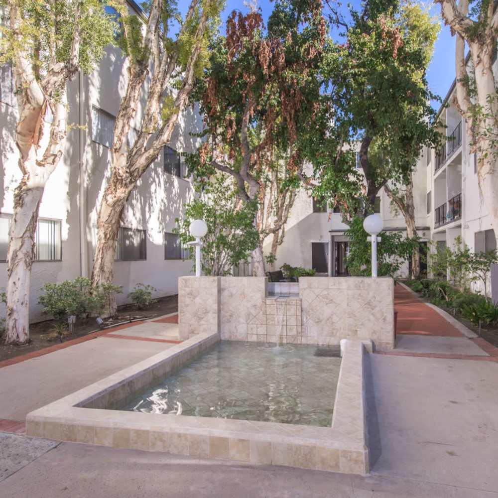 Apartment courtyard with fountain and trees at Tarzana Springs in Tarzana, California