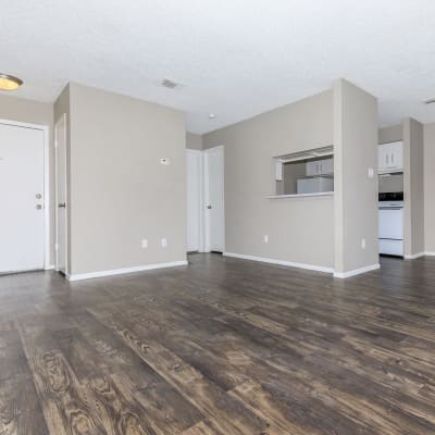 Apartment living room with wood-style flooring at CrescentWood Apartments in Clute, Texas