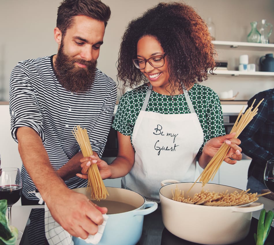Residents cooking up a delicious pasta dish in their new home at Sofi Ventura in Ventura, California