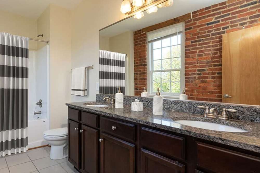 Large vanity with granite countertop in the apartment bathroom at High Street Lofts in Petersburg, Virginia