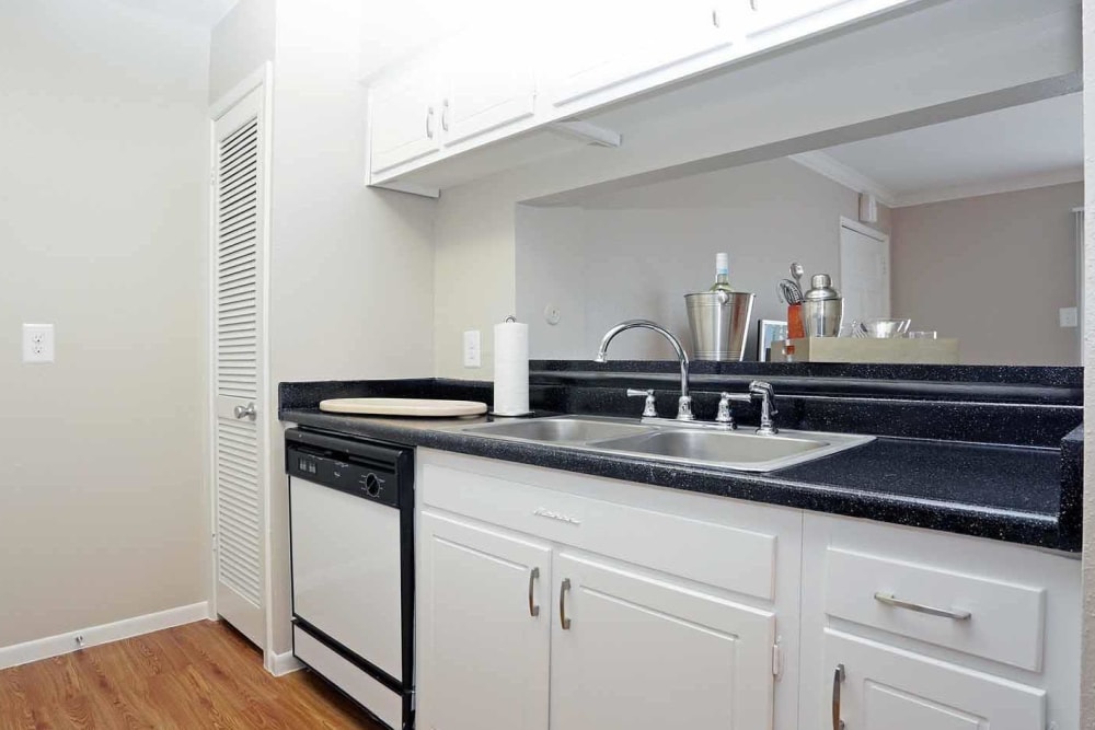 A kitchen with under-cabinet opening to the living room at Brittany Place Apartments in Houston, Texas