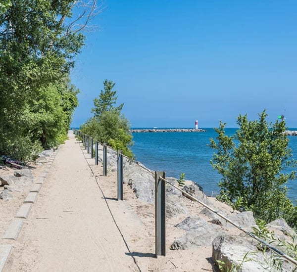 Waterside walkway and lighthouse in the distance at The Marquis at the Woods in Webster, New York