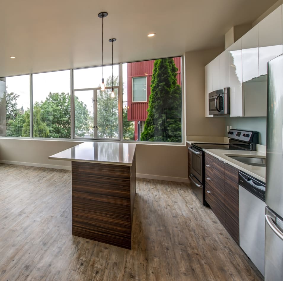 Modern kitchen with an island and stainless-steel appliances in the open-concept floor plan of a model home at Verse Seattle in Seattle, Washington