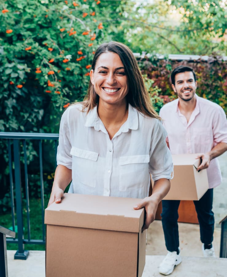 A smiling couple carrying items to store at Missouri Flat Storage Depot in Placerville, California