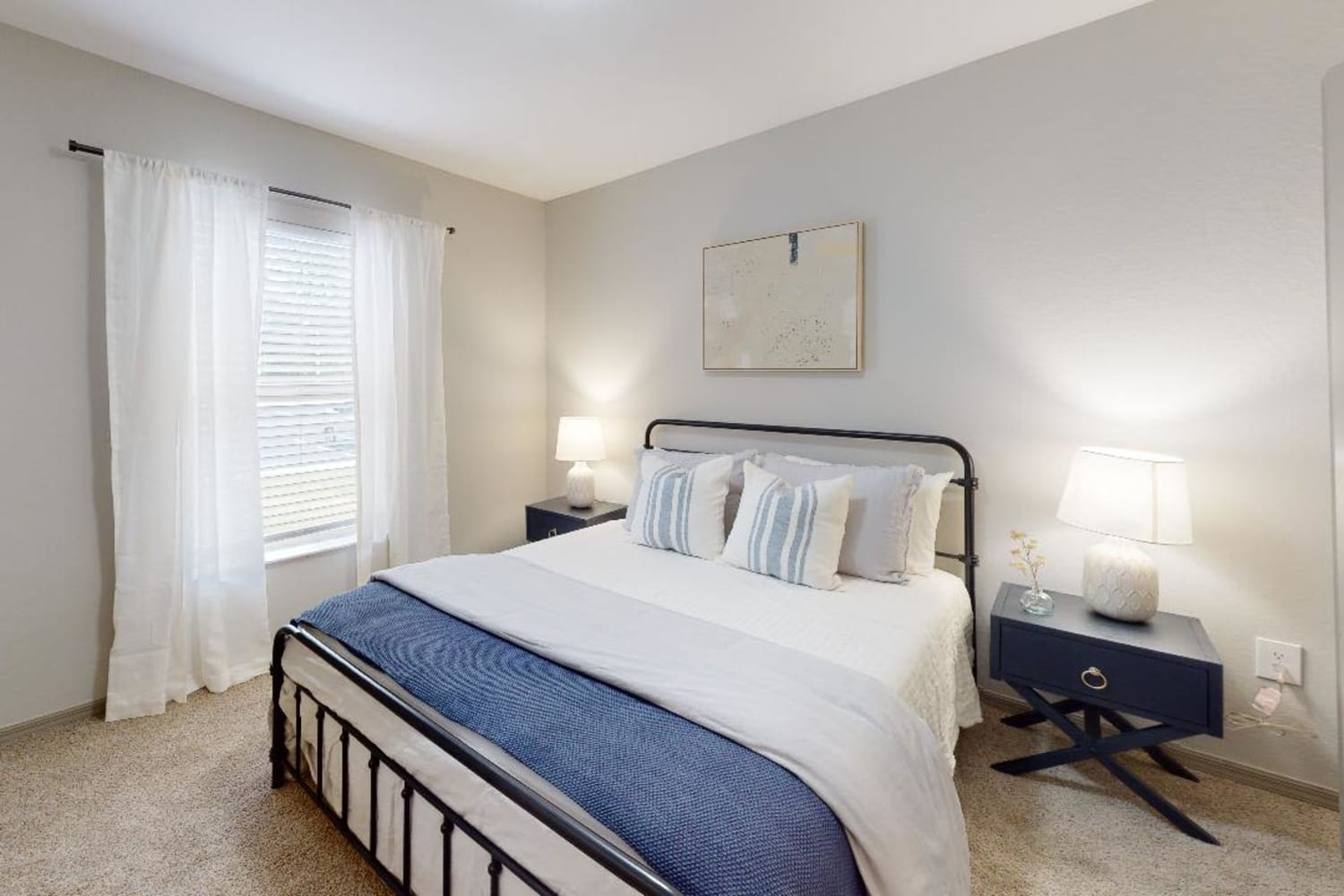 Hardwood-style flooring and draped windows in a model home's bedroom at The Jasper in Augusta, Georgia