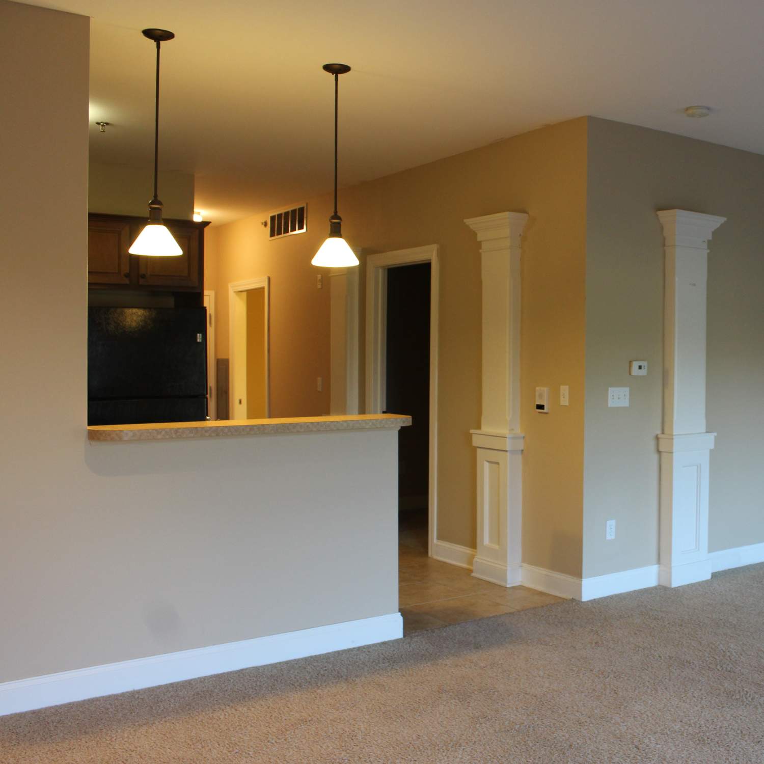 Apartment living room with hanging light fixtures at The Quarters East Lansing in East Lansing, Michigan