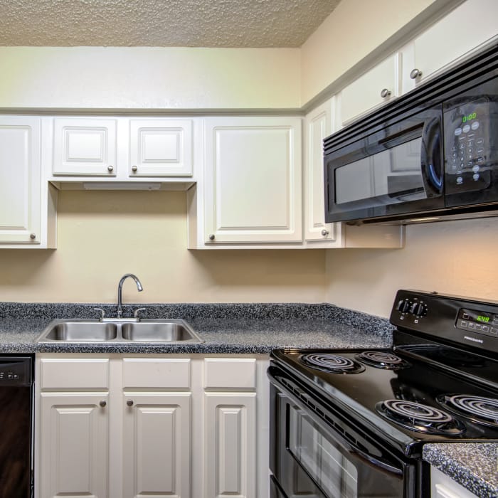 Modern kitchen with black appliances in model home at Grayson Ridge in North Richland Hills, Texas