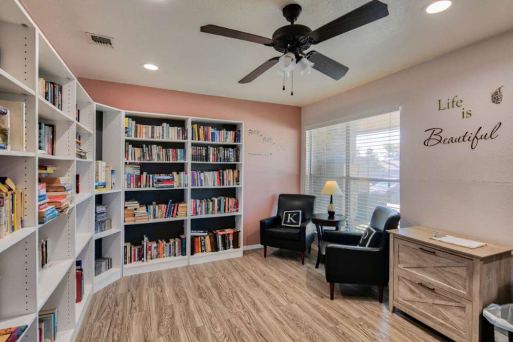 Community clubhouse with seating and book shelf at King Place Apartments in Greenville, Texas