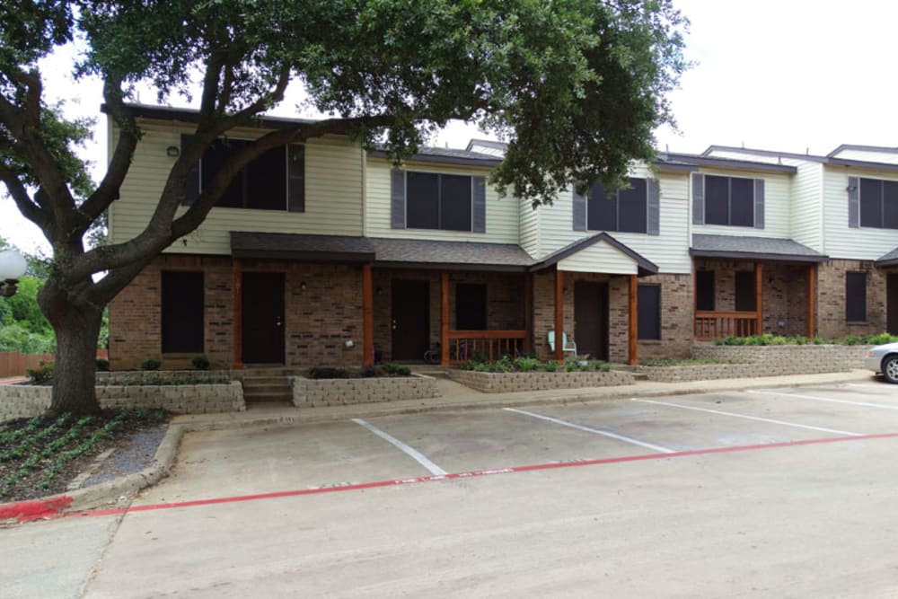 Two story townhomes and parking lot at Round Rock Townhomes in Arlington, Texas