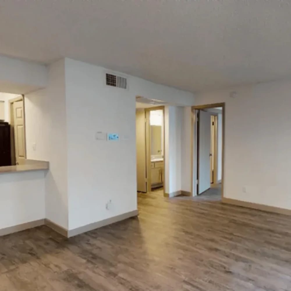 Spacious open layout with wood-style flooring at The Larsen Apartments in Dallas, Texas