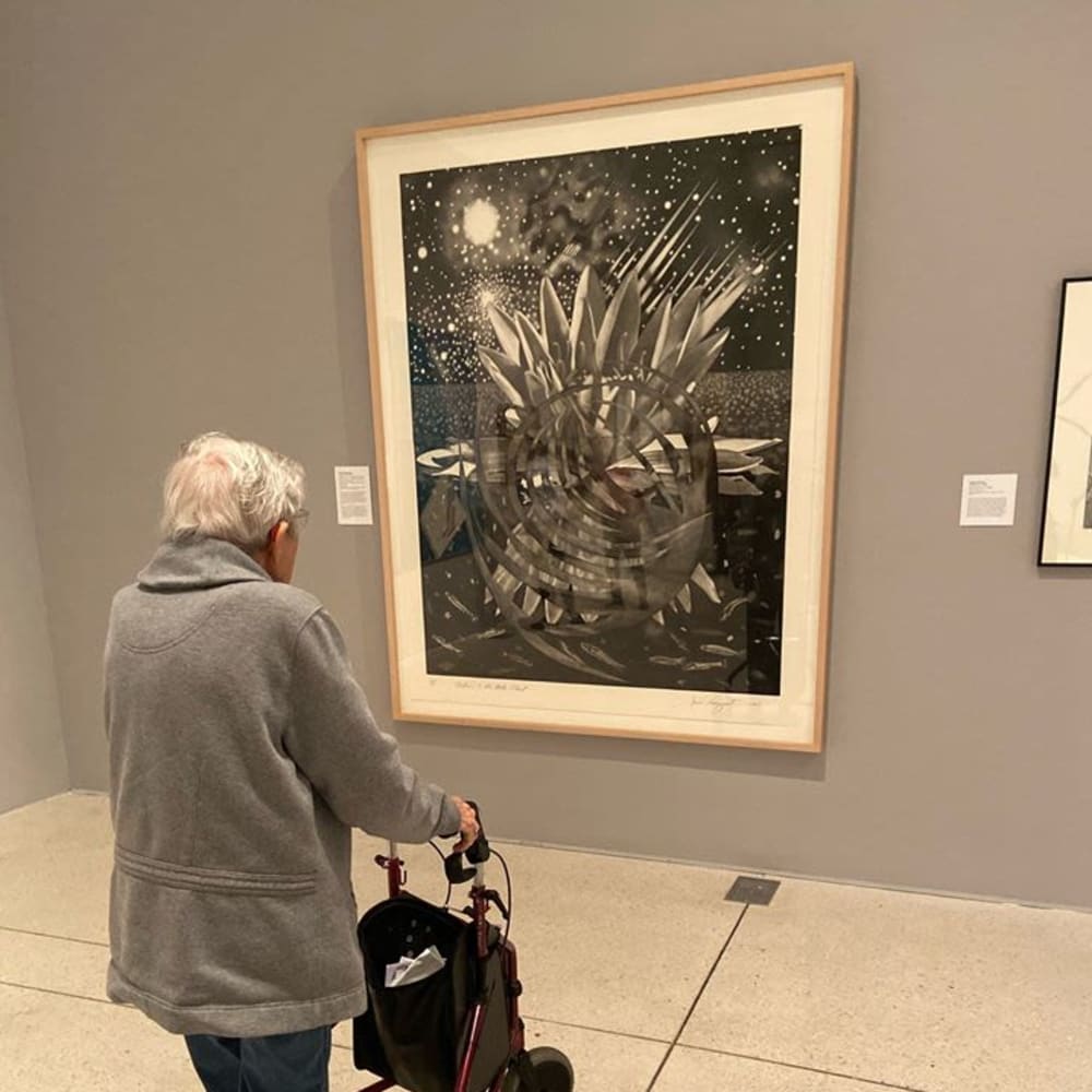 A resident looking at art at Inspired Living Tampa in Tampa, Florida. 