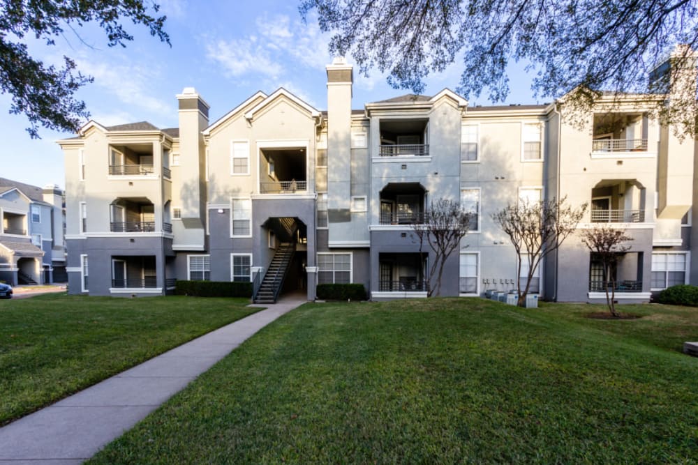 Unit entrance surrounded by green landscaping at Marquis at Stonegate in Fort Worth, Texas
