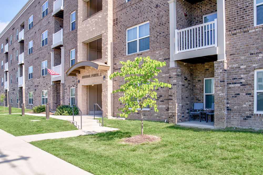 Building exterior with greenery all around at Brennan Pointe I in Newport News, Virginia