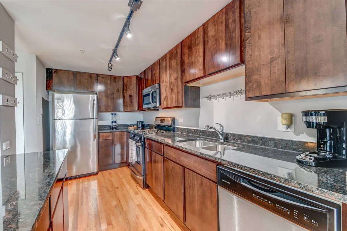Kitchen with granite countertops, appliances and wooden cabinets at 21 Kristin Apartments in Schaumburg, Illinois