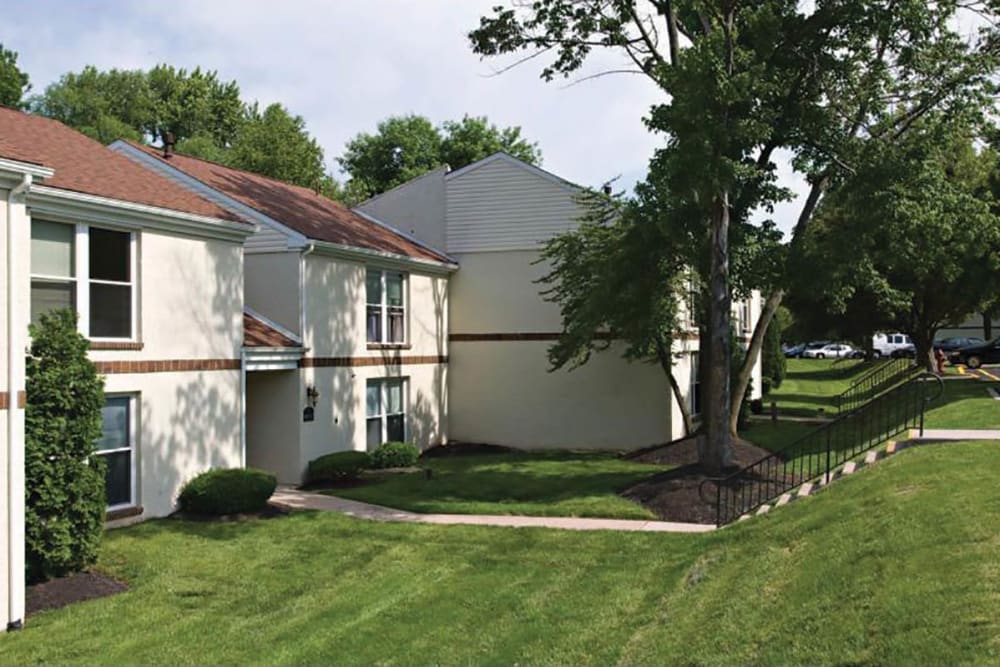 Exterior and park-like setting of Hill Brook Place Apartments in Bensalem, Pennsylvania