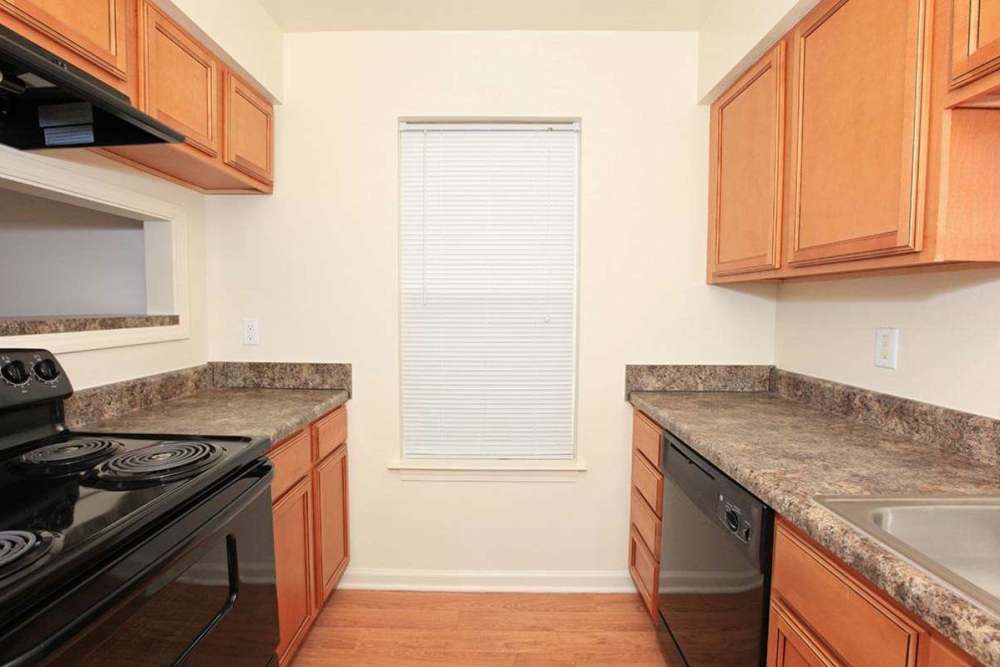 Kitchen with black appliances and granite countertop at Maplewood in Chesapeake, Virginia
