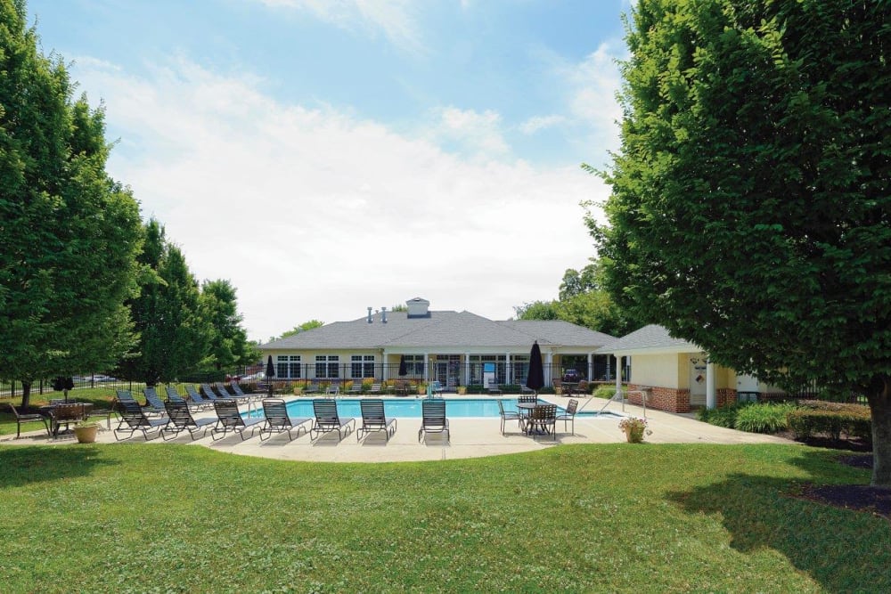 Sunny lawn and swimming pool at Hill Brook Place Apartments in Bensalem, Pennsylvania