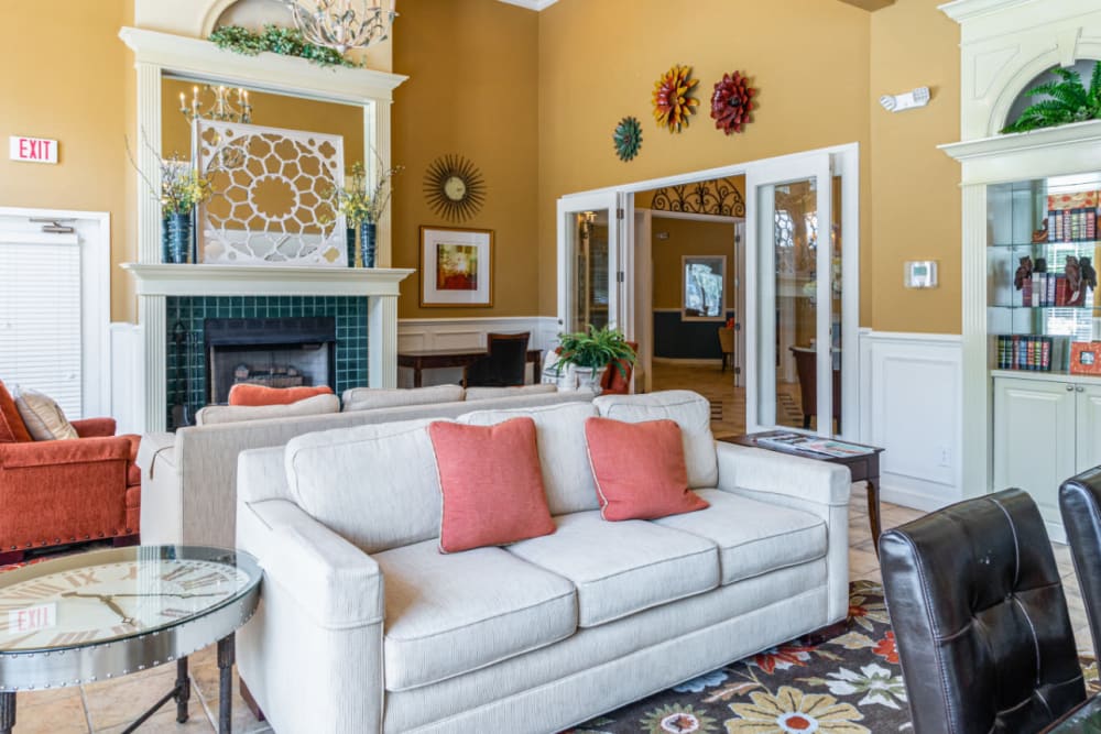 Community clubhouse sitting area with sofas and large fireplace at Marquis of Carmel Valley in Charlotte, North Carolina