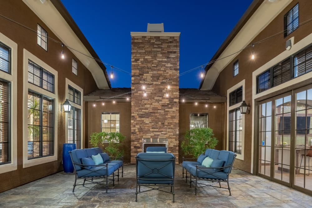 Cushioned chairs and couch area with outdoor fireplace at sunset at Marquis at Sonoran Preserve in Phoenix, Arizona