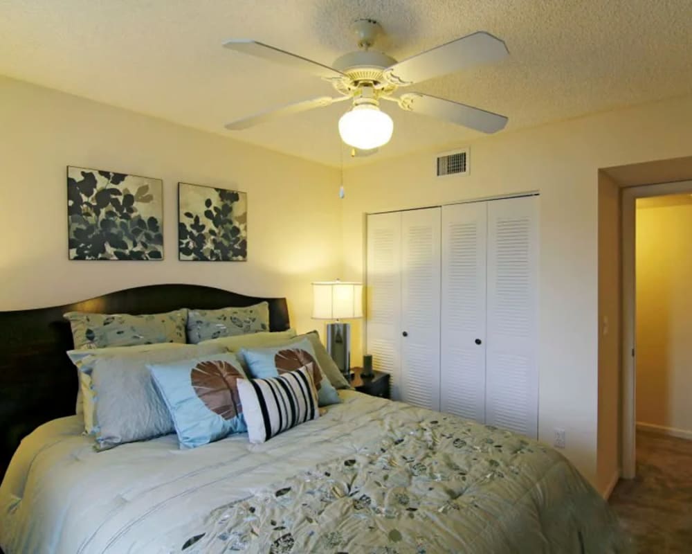 Bedroom with wall art and ceiling fan at  San Marco Apartments in Ormond Beach, Florida