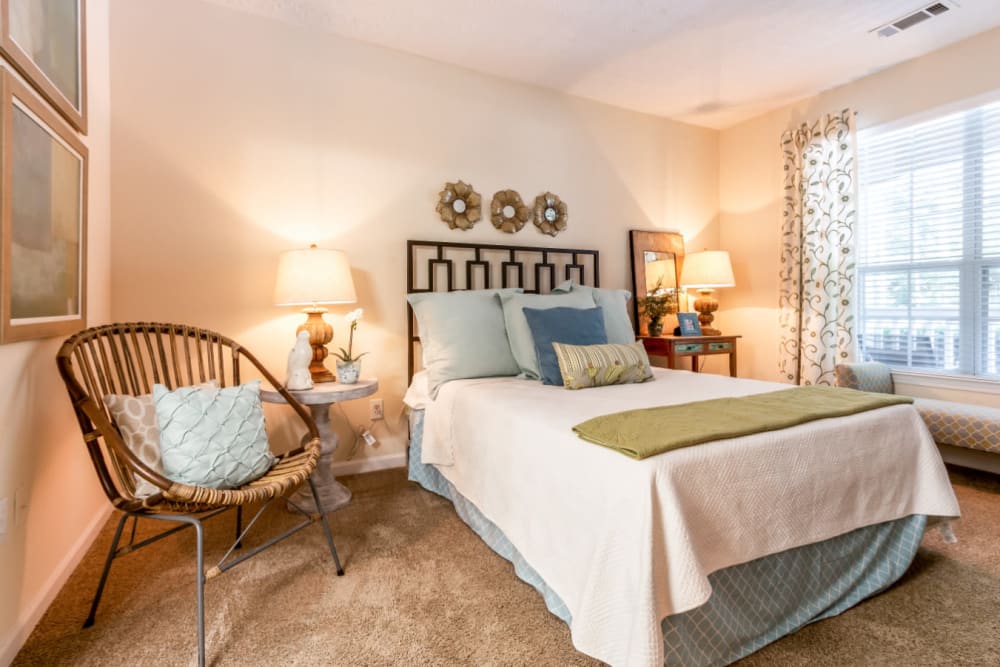 Spacious carpeted bedroom with large window at Marquis at Sugarloaf in Duluth, Georgia