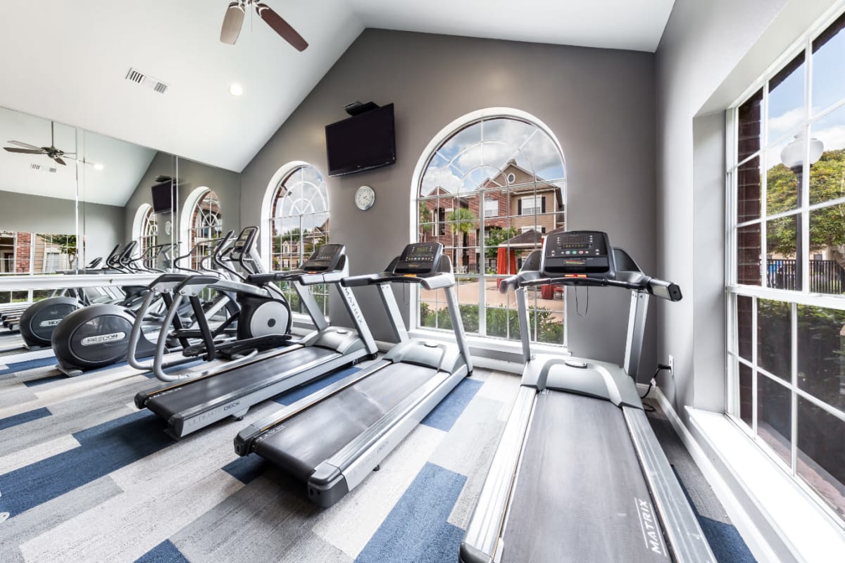 Treadmills and elliptical with view of pool deck at Marquis on Park Row in Houston, Texas
