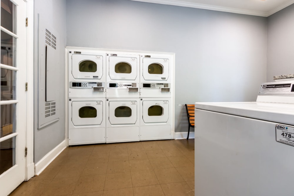 Coin operated dryer machines in community laundry room at Marquis at Sugarloaf in Duluth, Georgia