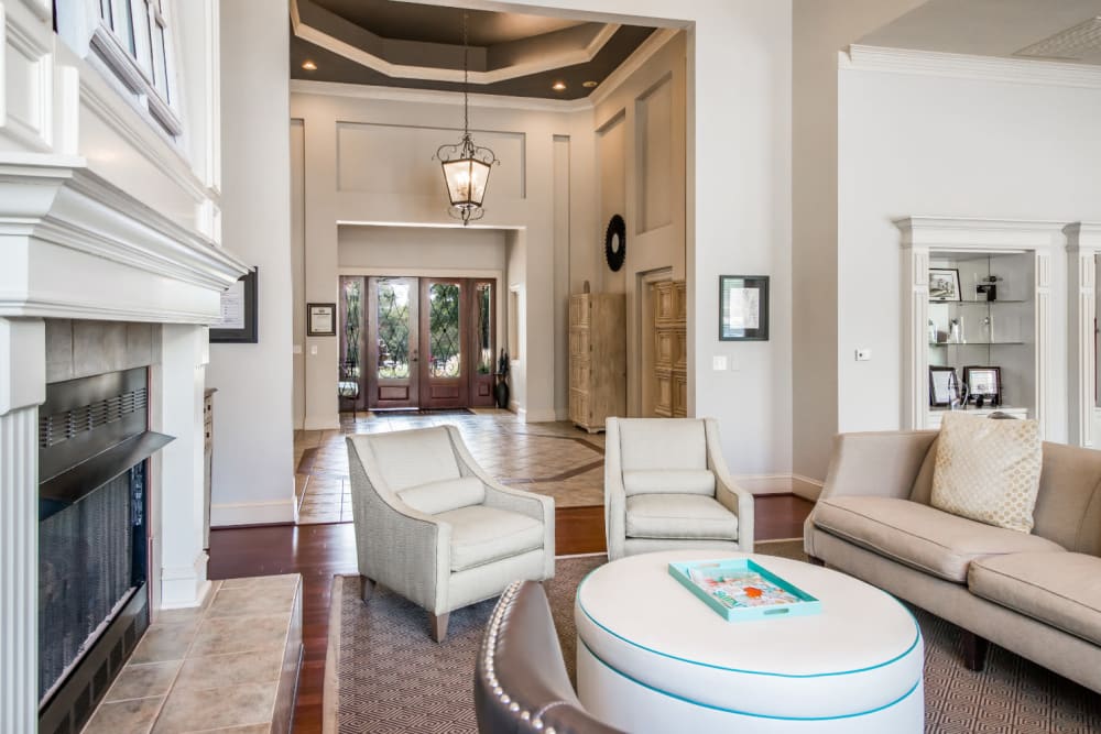 Stylish and comfortable sitting area next to fireplace in clubhouse at Marquis at Carmel Commons in Charlotte, North Carolina