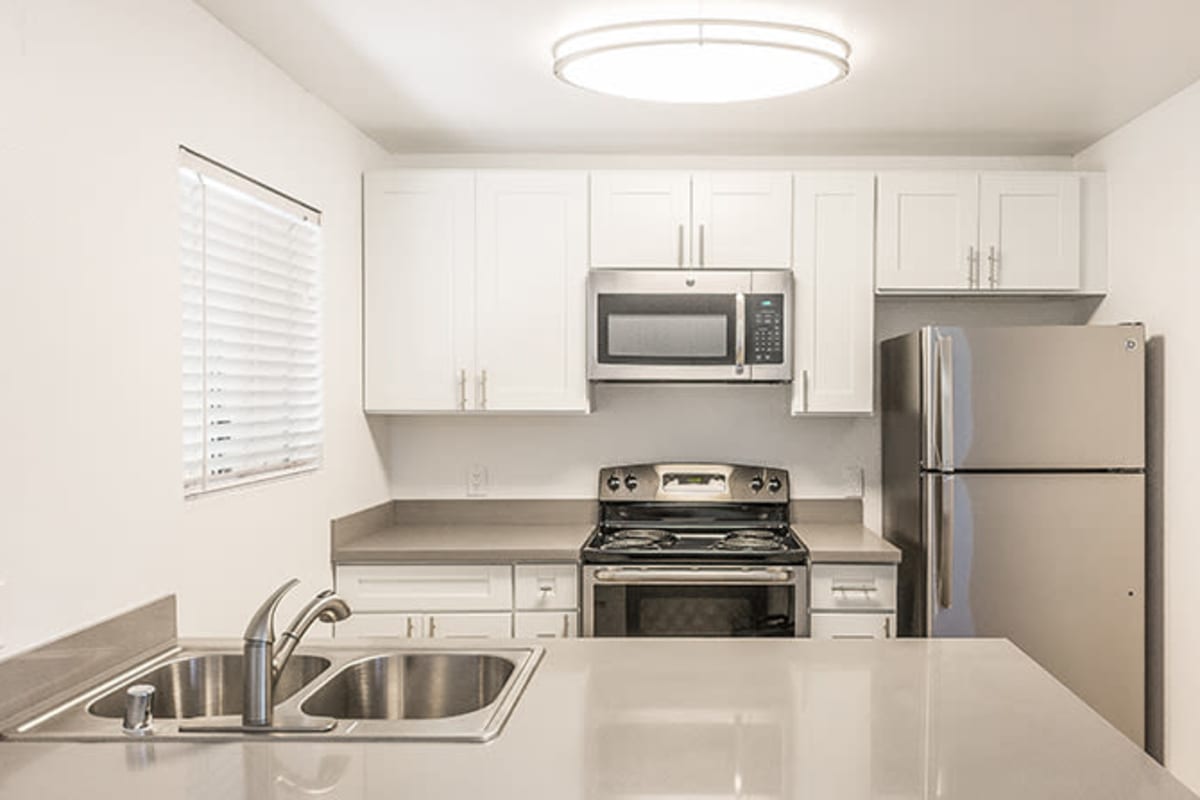 Kitchen with stainless-steel appliances at The Avenue at Carlsbad in Carlsbad, California