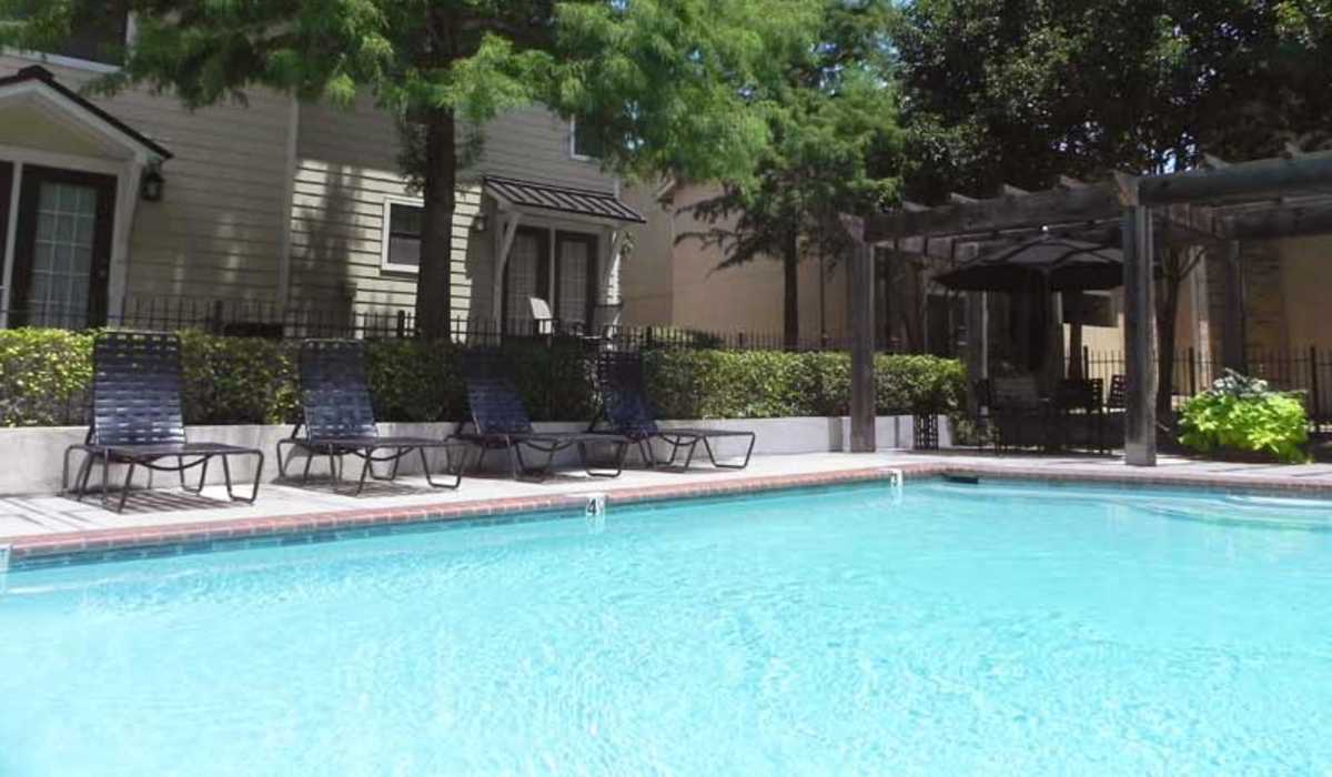 Swimming pool surrounded by lounge chairs at Highcrest in San Marcos, Texas